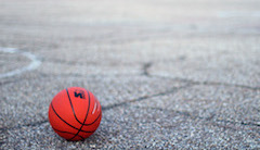 A lonely basketball on an empty basketball court