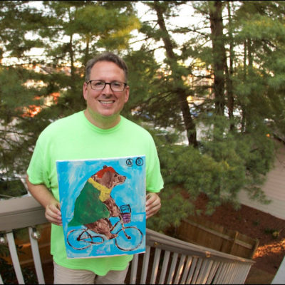 Joe Donnelly holding up an office bear painting