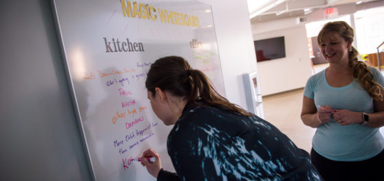 Rustici staff writing in requests on the Magic Whiteboard